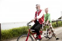 Senior couple sightseeing on tandem bicycle — Stock Photo