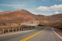 Strada di campagna vuota che passa attraverso belle montagne — Foto stock