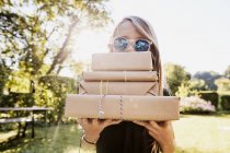 Chica llevando paquetes de papel marrón - foto de stock
