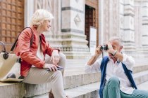 Sénior homem turista fotografando esposa na escada da catedral de Siena, Toscana, Itália — Fotografia de Stock