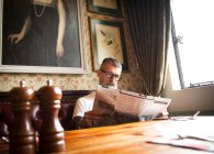 Uomo eccentrico che legge giornali in bar e ristorante, Bournemouth, Inghilterra — Foto stock