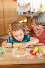 Petits-enfants et grand-mère faire des biscuits — Photo de stock