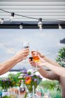 Hands of men and women raising a family wine toast at patio table — Stock Photo