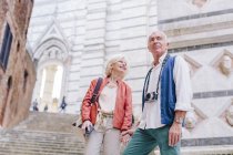 Tourist couple with camera and smartphone by city stairway, Siena, Tuscany, Italy — Stock Photo