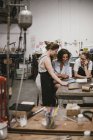 Three female jewelers looking at digital tablet at workbench — Stock Photo