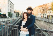 Portrait of cool couple by city canal — Stock Photo