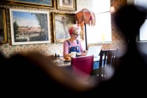 Donna eccentrico utilizzando il computer portatile in bar e ristorante, Bournemouth, Inghilterra — Foto stock