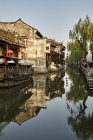 Imagen de espejo de la vía navegable y el edificio tradicional, Xitang Zhen, Zhejiang, China - foto de stock