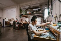 Homme bijoutier travaillant à l'atelier de bijouterie établi — Photo de stock