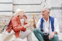 Tourist couple eating ice cream cones and laughing in Siena, Tuscany, Italy — Stock Photo