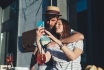Casal tomando selfie smartphone no café calçada — Fotografia de Stock
