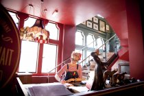 Femme bizarre travaillant au comptoir haut au bar et restaurant, Bournemouth, Angleterre — Photo de stock
