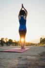 Reife Frau im Freien, stehend in Yogaposition, Rückansicht — Stockfoto
