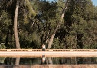 Female tourist looking sideways by lake in Labyrinth Park of Horta, Barcelona, Spain — Stock Photo