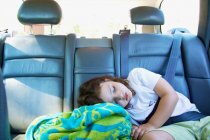 Chica dormida en coche con cinturón de seguridad en - foto de stock
