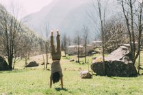 Junger Mann macht Handstand im Tal — Stockfoto