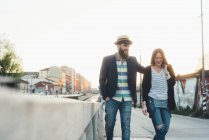 Couple hipster flânant par le canal de la ville — Photo de stock
