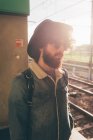 Молодий чоловік стоїть на залізничній платформі — стокове фото