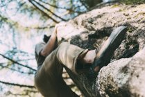 Low angle view of male climbing on boulder — Stock Photo