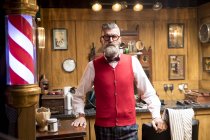 Retrato de homem sênior peculiar na tradicional velha barbearia inglesa — Fotografia de Stock