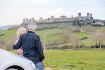Rear view of tourist couple looking at fort in landscape, Siena, Tuscany, Italy — Stock Photo