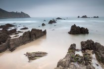 Хвилі, що миються на кам'янистому пляжі — стокове фото
