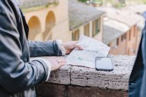 Tourist couple looking at map on wall, Siena, Tuscany, Italy — Stock Photo