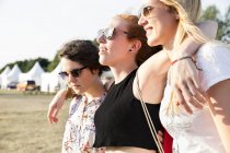 Tres amigas disfrutando del festival al aire libre - foto de stock