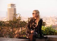 Светловолосая туристка, сидящая на стене, Барселона, Испания — стоковое фото