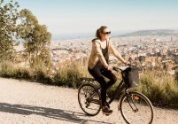 Frau Sightseeing auf Fahrrad, Stadt im Hintergrund, Barcelona, Katalonien, Spanien — Stockfoto