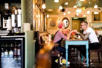 Pareja extraña relajándose en el bar y restaurante, Bournemouth, Inglaterra - foto de stock