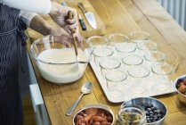 Шеф-кухарі готують ягідні десерти та змішують вершки — стокове фото