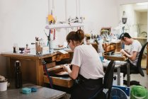 Жіночі та чоловічі ювеліри, що працюють на робочому місці — стокове фото