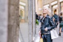 Reife frau einkaufen auf city street, siena, toskana, italien — Stockfoto