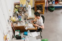High angle view of male jeweller using blow torch at workbench — Stock Photo