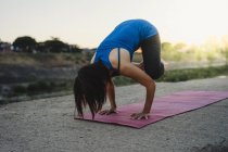 Зріла жінка на відкритому повітрі, балансування на руках в положенні йоги — стокове фото