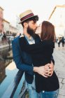 Hipster couple kissing by city canal — Stock Photo