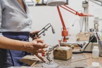Mid section of female jeweler using blow torch at workbench — Stock Photo
