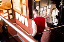 Hombre bajando escaleras en bar y restaurante, Bournemouth, Inglaterra - foto de stock