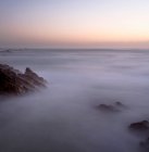 Aerial view of majestic rocky coastline in fog at sunset — Stock Photo