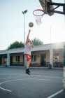 Чоловік стрибає до баскетбольного кільця на дитячому майданчику — стокове фото