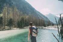 Вид сзади на туриста-мужчину с видом на горное озеро Ломбардия, Италия — стоковое фото