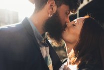 Casal legal beijando na rua iluminada pelo sol — Fotografia de Stock