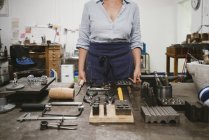 Juwelierin legt Handwerkzeug an Werkbank in Schmuckwerkstatt aus — Stockfoto
