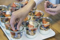 Image recadrée de Chef préparant des desserts aux myrtilles et fraises — Photo de stock