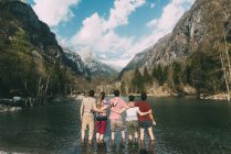 Вид на пятерых взрослых друзей по щиколотку глубоко в горном озере, Ломбардия, Италия — стоковое фото