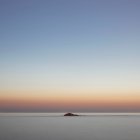 Hermosa vista panorámica de la roca en el mar al atardecer - foto de stock