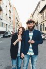 Portrait of happy couple with cocktails on city street — Stock Photo