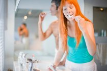 Couple brushing their teeth in bathroom — Stock Photo