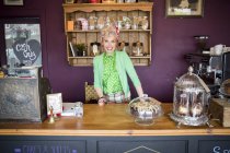 Portrait of vintage mature woman behind counter in tea room — Stock Photo